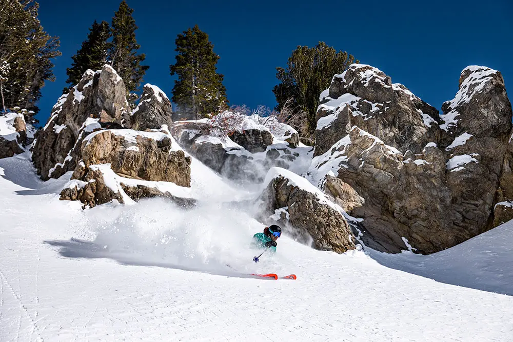 Skier infront of cliff at Snowbird during the Big Mountain Camp, staying with the lodging special