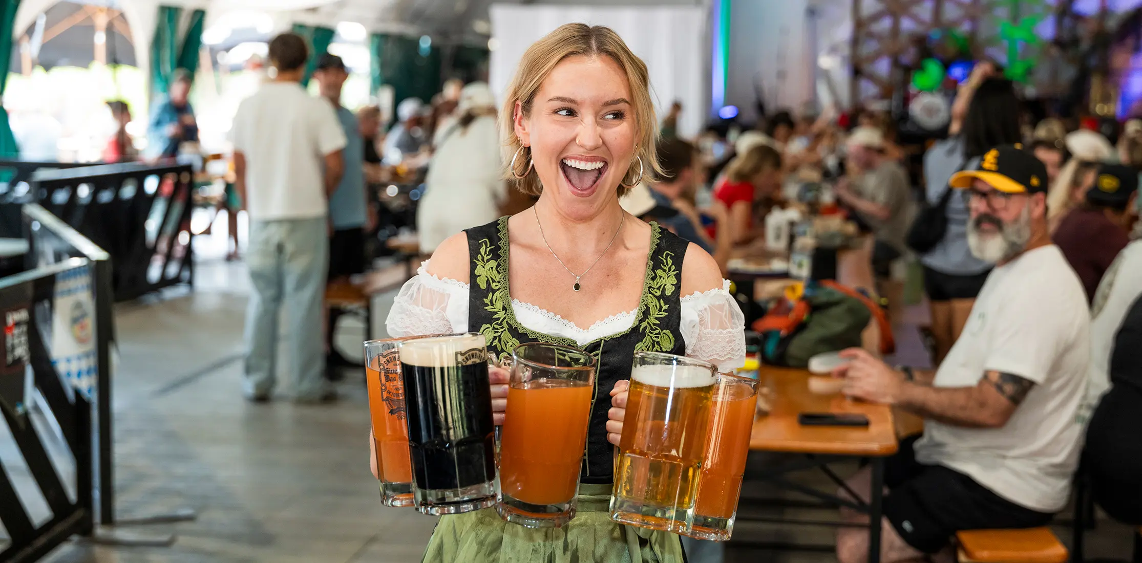 person in Oktoberfest outfit carries 5 beers at Snowbird