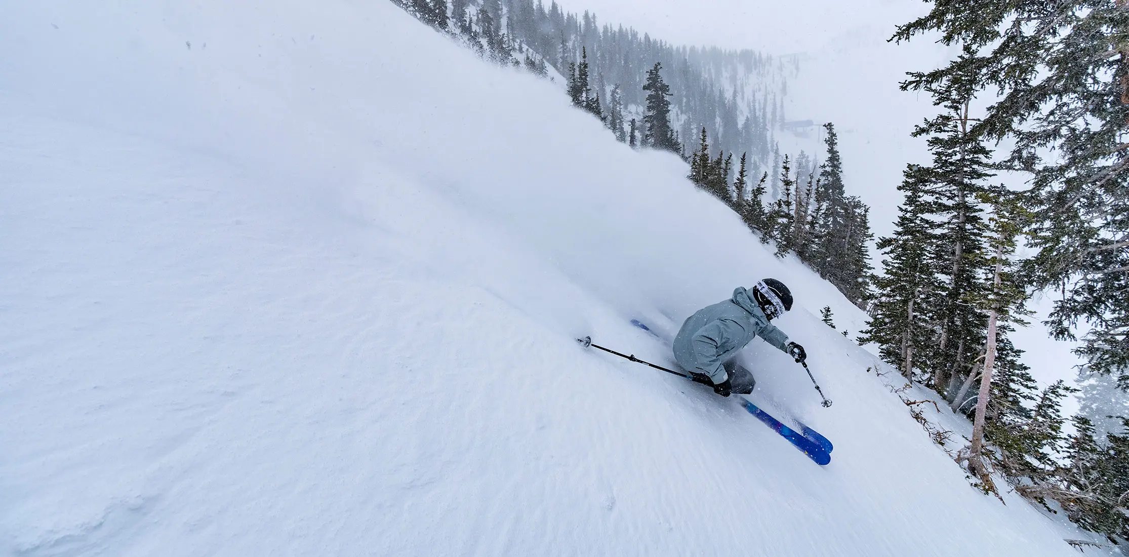 Skier in powder in a steep bowl at Snowbird