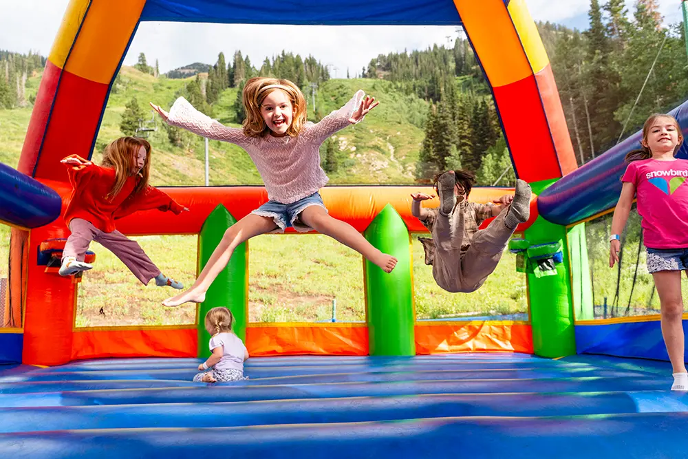 Kids jumping on the inflatables at Snowbird during summer activities
