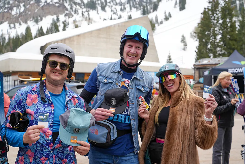 Snowbird Passholders holding up swag and their passes