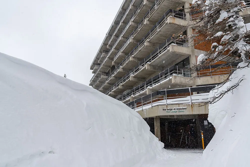 Exterior of The Lodge at Snowbird with snow piled up near the entrance in winter
