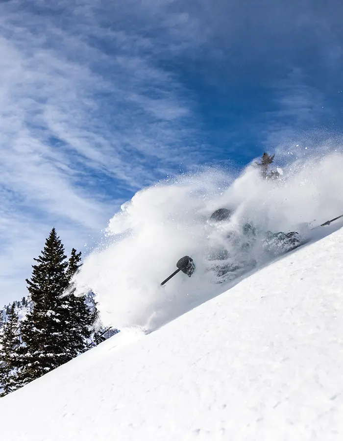 Skier in deep powder with mineral basin in the background - mobile hero for Snowbird Mountain Report