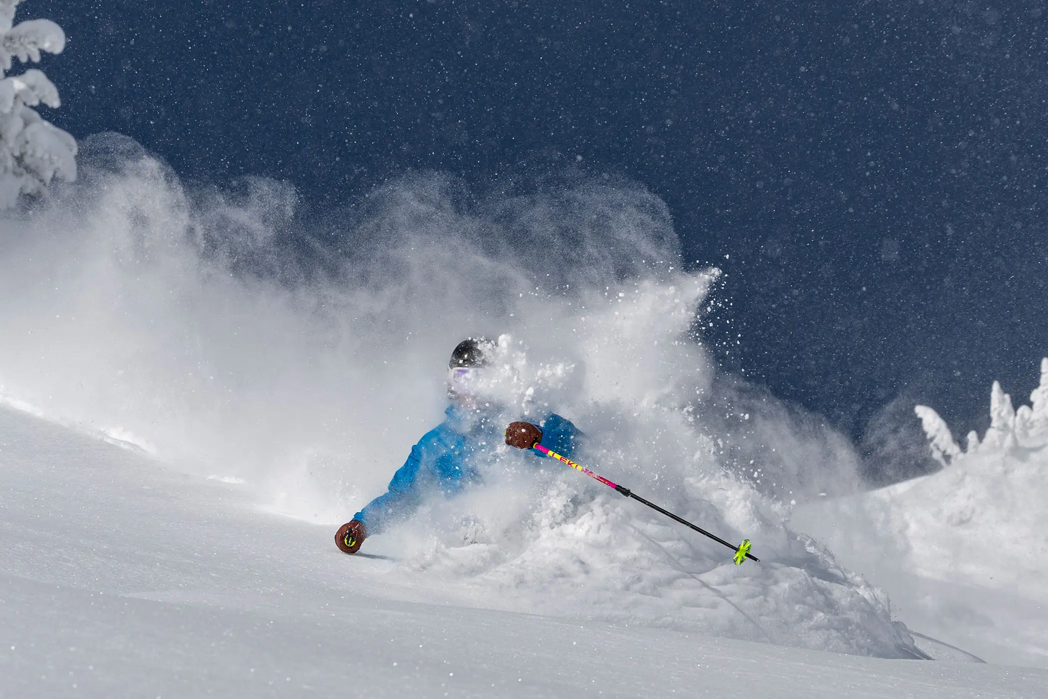 Skier on a deep powder day making a turn. Lodging guests receive discounts on skiing