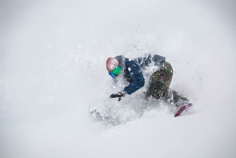 Snowbird employee snowboarding in powder as one of the perks of working at a ski resort