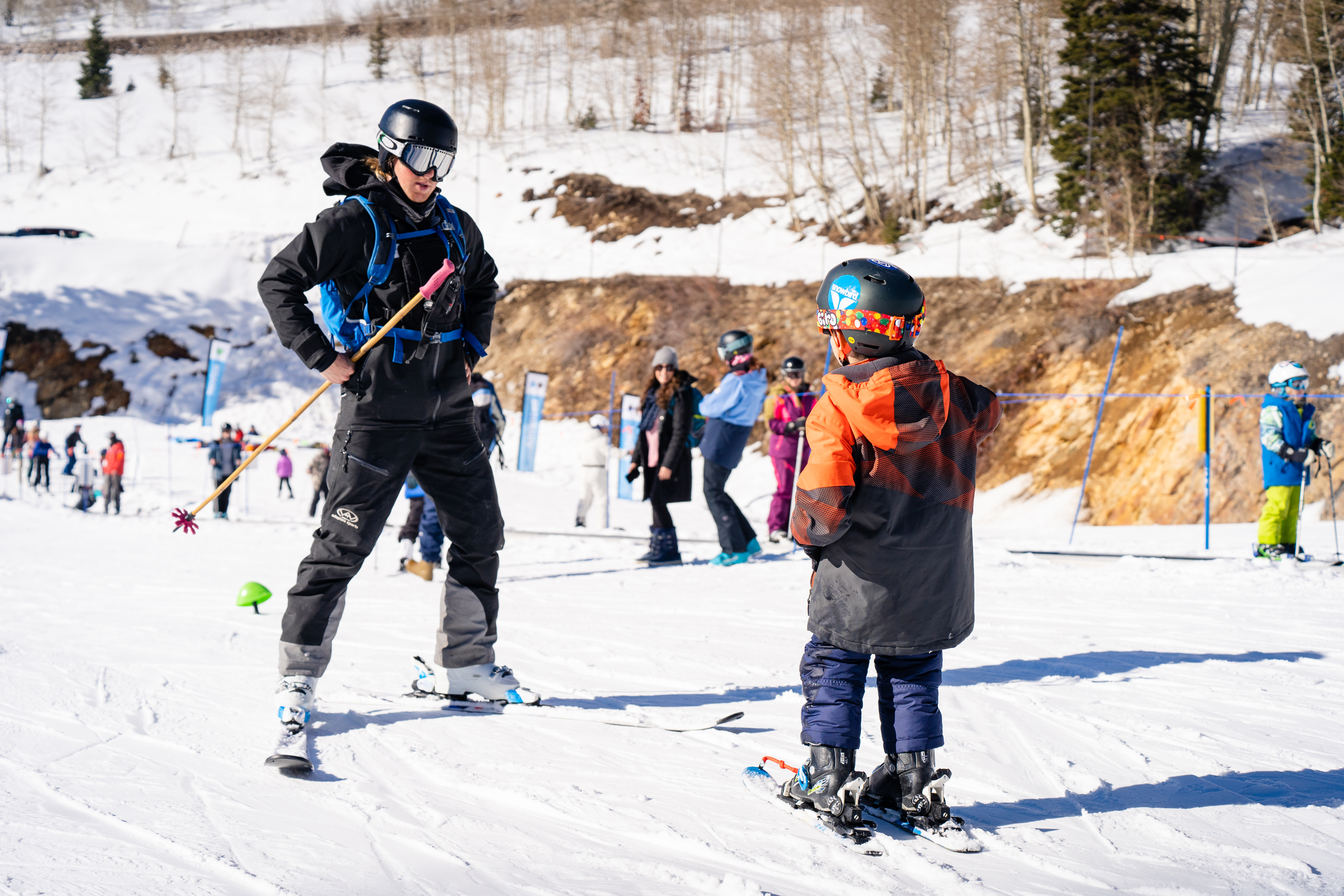 Wasatch Adaptive team member teaching young kid how to ski at Snowbird