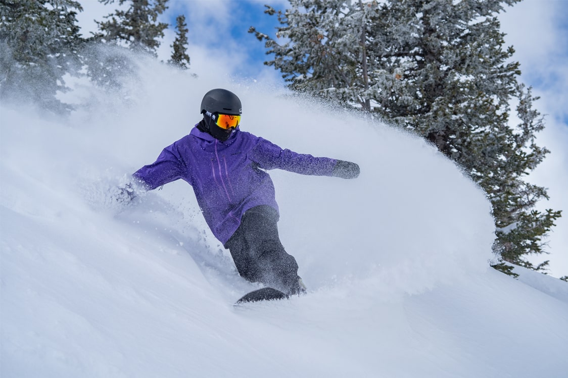 Snowboarder riding in powder